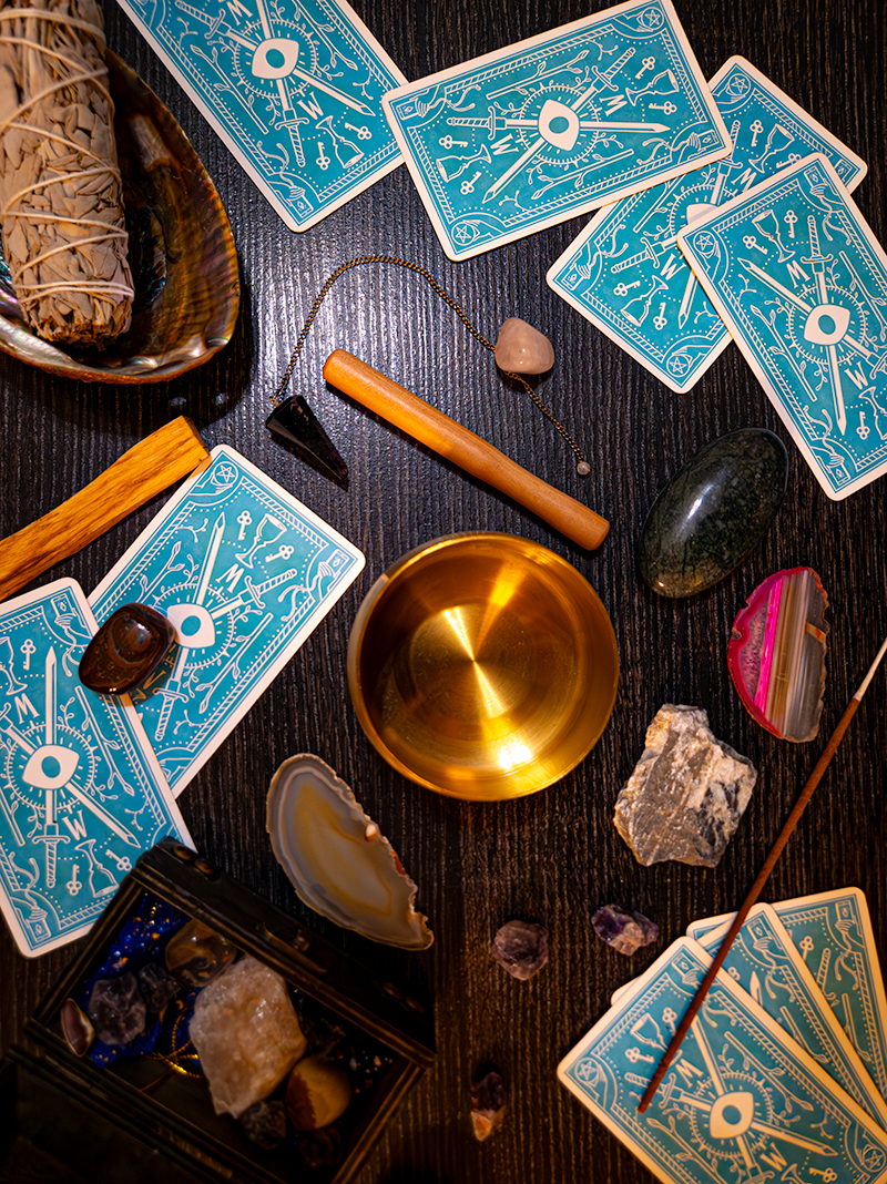 top down photo of singing bowl, crystals, sage, tarot cards